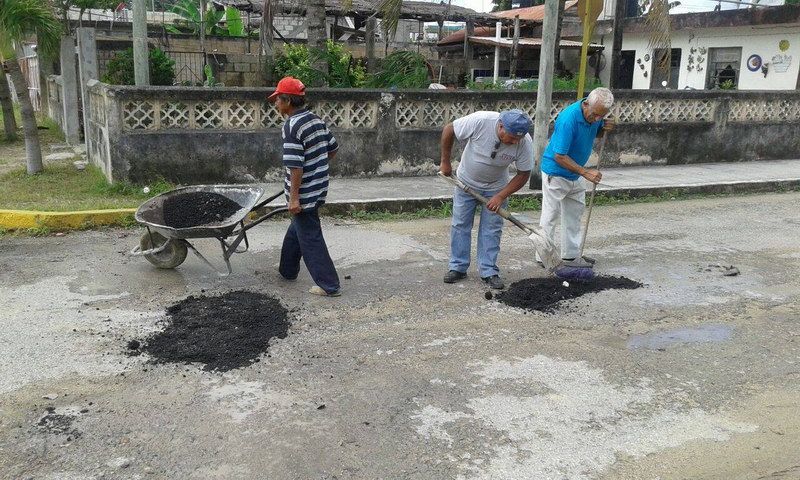 Vecinos salen al quite en bacheo de sus calles