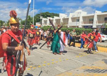 Feligreses participan en representación del viacrucis en el centro de Tulum