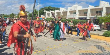 Feligreses participan en representación del viacrucis en el centro de Tulum